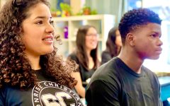 students smiling together while seated at a classroom table, enjoying a lesson